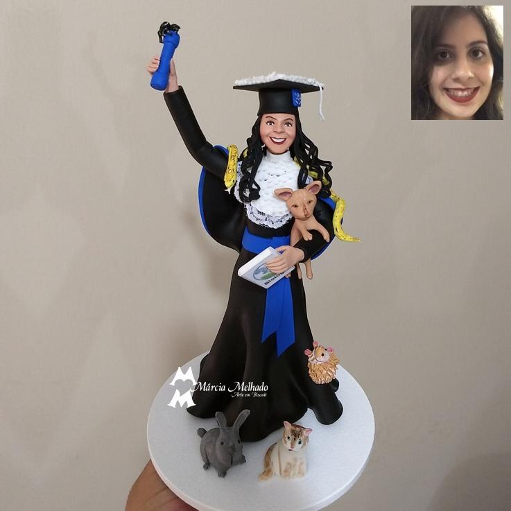 Boneca de formatura azul com vários bichinhos e livro