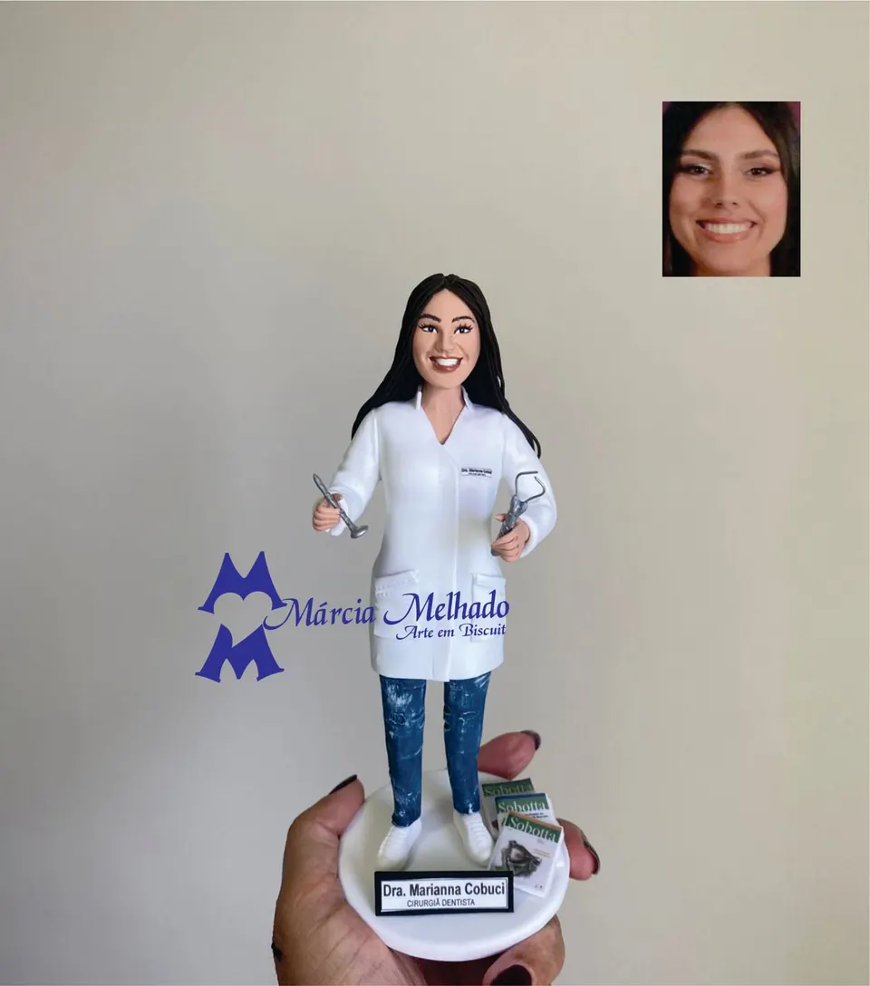 Boneca cirurgiã dentista de jaleco branco com livros de anatomia Boneca de biscuit de dentista com jaleco branco, calça jeans, instrumentos odontológicos nas mãos e livros de anatomia