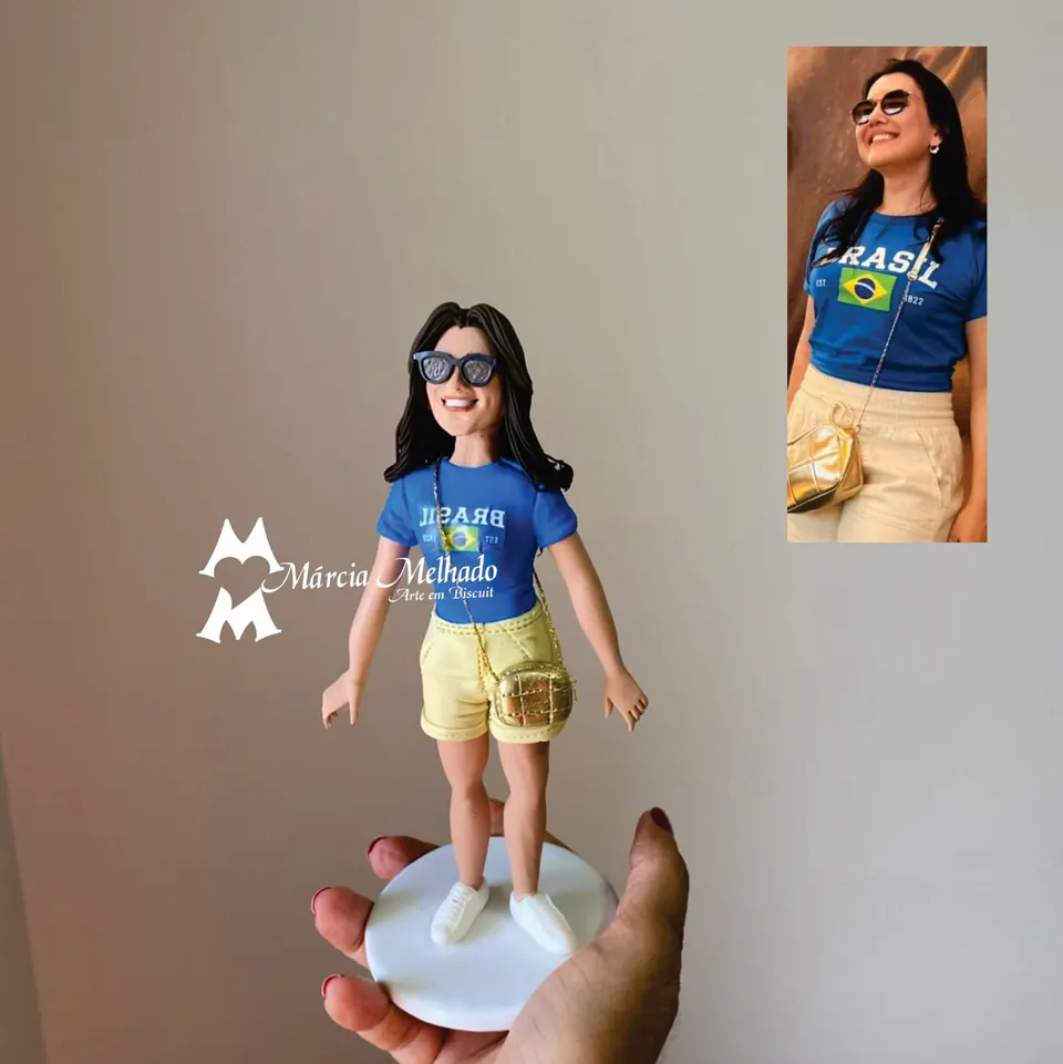 Boneca com camiseta do Brasil, óculos escuros e bolsa dourada Boneca de biscuit de cabelo escuro com óculos de sol, camiseta azul do Brasil, shorts bege e bolsinha dourada a tiracolo