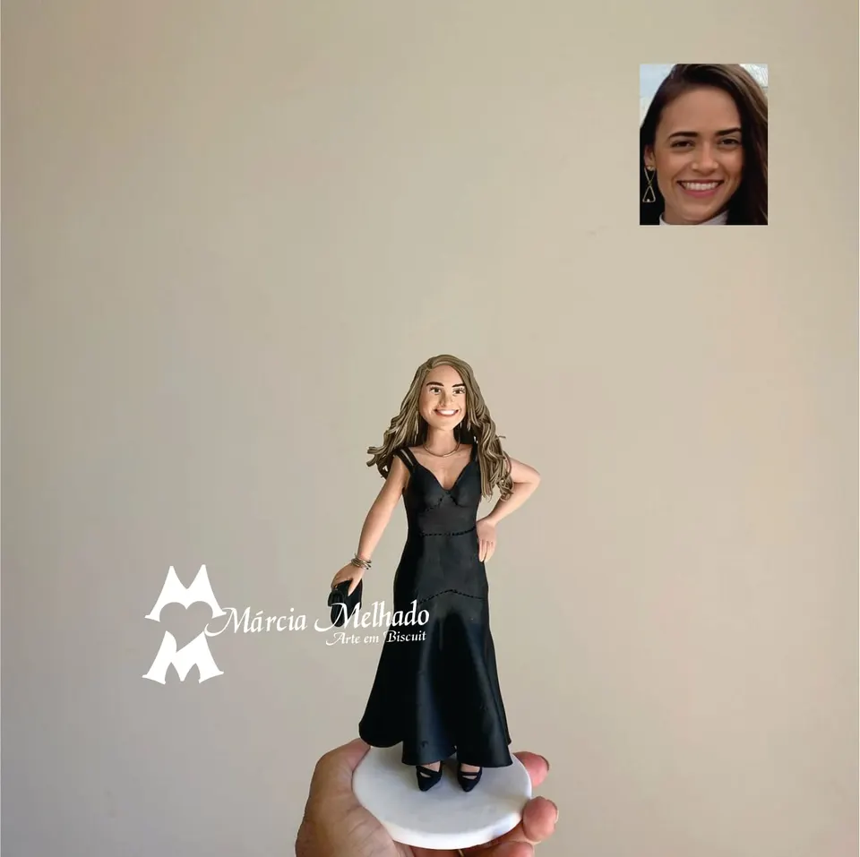 Boneca com vestido longo preto e bolsa de mão Boneca de biscuit de mulher com cabelos longos e vestido longo preto de alças, segurando bolsa de mão sobre base branca