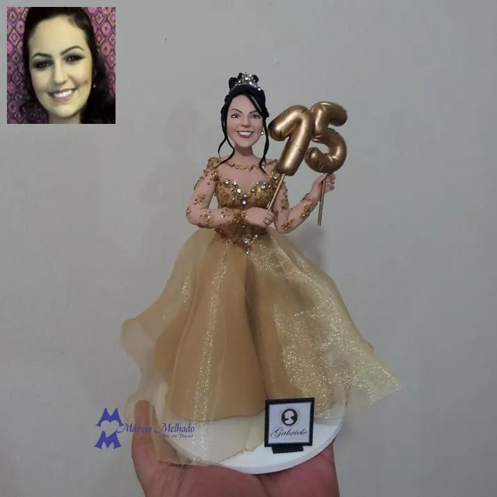 Boneca de 15 anos com vestido dourado e balão número 15 Boneca de biscuit de debutante com tiara, vestido dourado bordado e saia de tule segurando balão dourado com o número 15