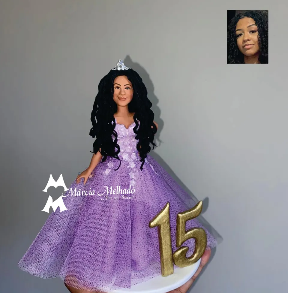 Boneca de 15 anos com vestido lilás de tule e número 15 dourado Boneca de biscuit debutante com cabelos cacheados, tiara e vestido lilás de tule brilhante ao lado do número 15 dourado