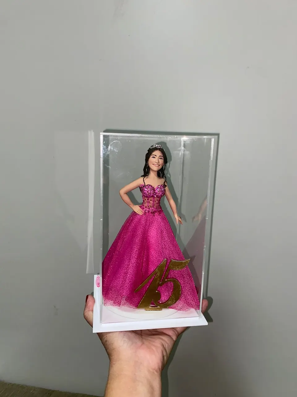 Boneca de 15 anos com vestido pink, tiara e número 15 dourado Boneca de biscuit de 15 anos com vestido pink de tule, tiara e número 15 dourado dentro de caixa de acrílico