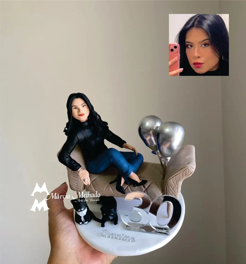 Boneca de aniversário 30 anos no sofá com dois gatos e balões Boneca de biscuit de cabelo preto e blusa preta sentada em sofá bege, com dois gatos pretos, balões prateados e número 30