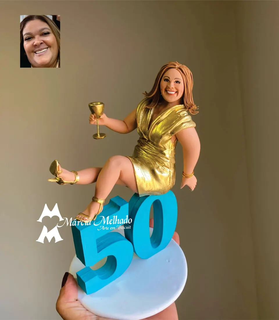 Boneca de aniversário 50 anos com vestido dourado sentada no número Boneca de biscuit de vestido dourado e sandálias douradas, com taça na mão, sentada sobre o número 50 azul turquesa