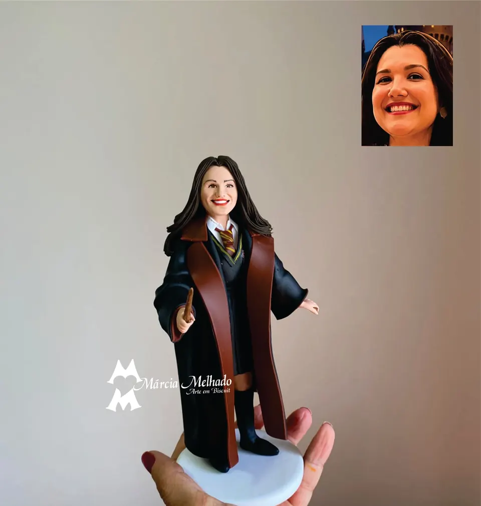 Boneca de bruxa de Hogwarts com varinha e uniforme da Grifinória Boneca de biscuit de cabelo escuro com capa preta de forro vermelho, gravata listrada da Grifinória e varinha em punho