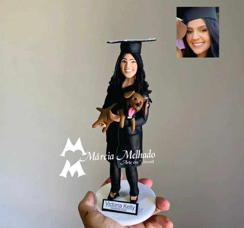 Boneca de formatura em odontologia com cachorro no colo Boneca de biscuit de formanda em odontologia de beca e capelo pretos com cachorro caramelo no colo
