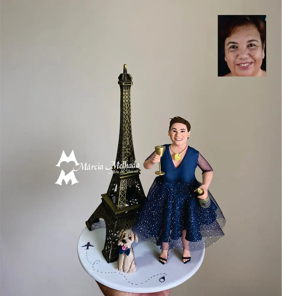 Boneca de viagem a Paris com torre Eiffel, taça e cachorro Boneca de biscuit com vestido azul brilhante segurando taça e garrafa ao lado de uma torre Eiffel, com cachorrinho na base