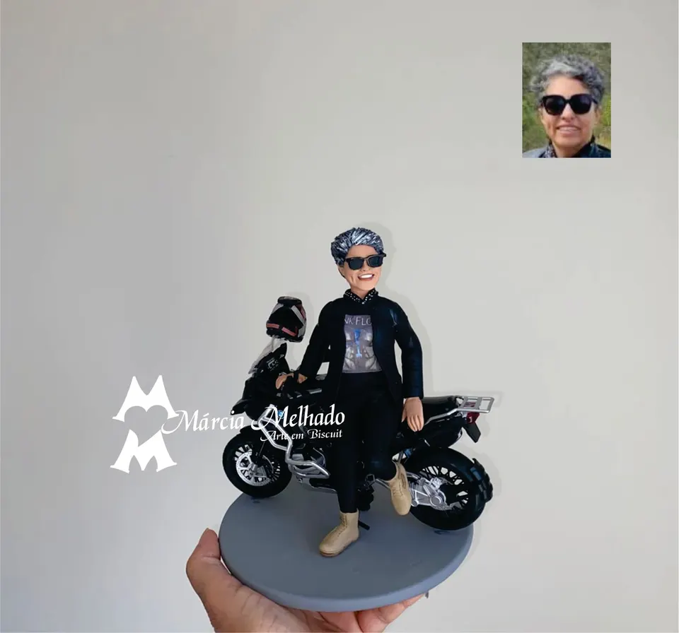 Boneca motociclista com moto de trilha e capacete Boneca de biscuit de motociclista com cabelo grisalho, óculos escuros e jaqueta preta sentada em uma moto preta com capacete
