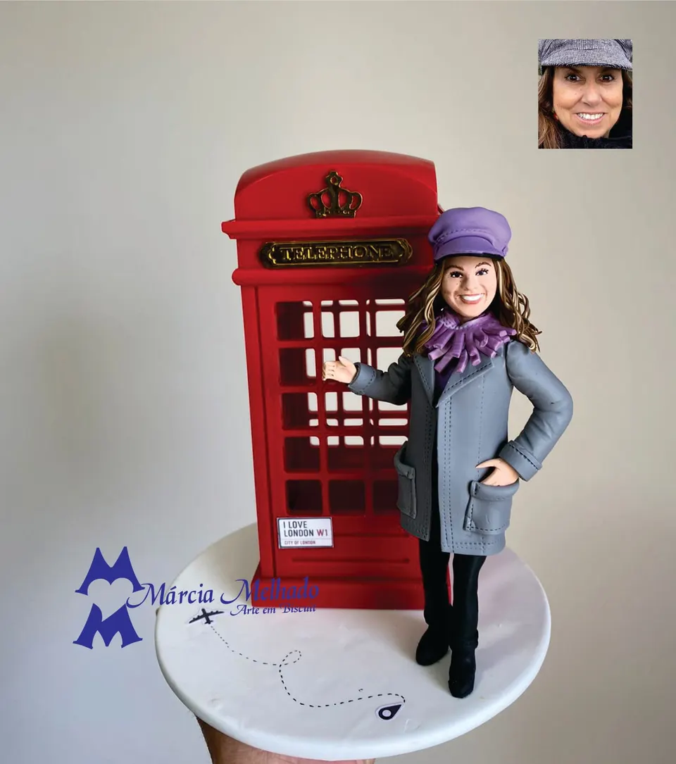 Boneca viajante em Londres ao lado da cabine telefônica vermelha Boneca de biscuit de mulher com boina e cachecol roxos e casaco cinza ao lado de uma cabine telefônica vermelha de Londres