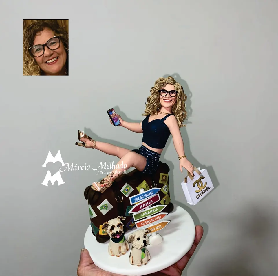 Boneca viajante sentada na mala com dois cachorros e sacola Chanel Boneca de biscuit loira de óculos sentada em uma mala de viagem com celular, sacola Chanel, placas e dois cachorros.