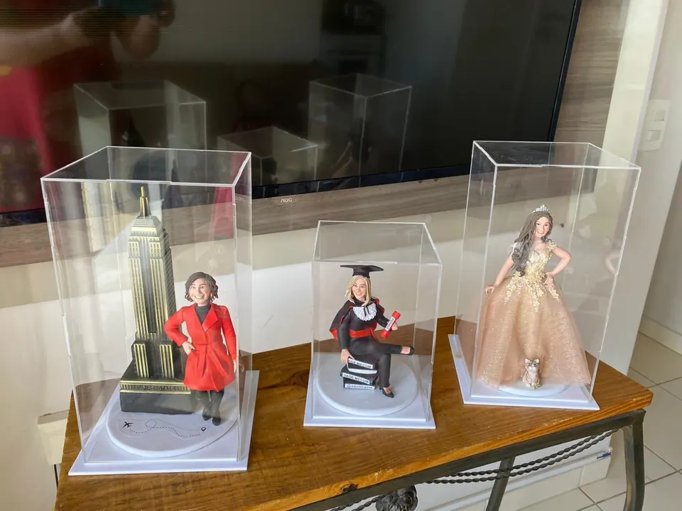 Bonecas em caixas de acrílico: viagem, formatura e 15 anos Três bonecas de biscuit em caixas de acrílico: viajante com Empire State, formanda de Direito e debutante com gato