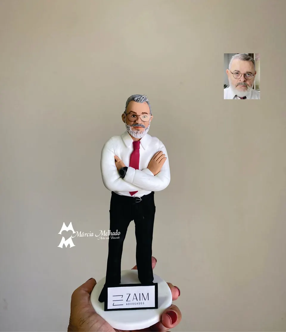 Boneco advogado de camisa branca e gravata vermelha com braços cruzados Boneco de biscuit de advogado grisalho de óculos com camisa branca, gravata vermelha e braços cruzados sobre base branca