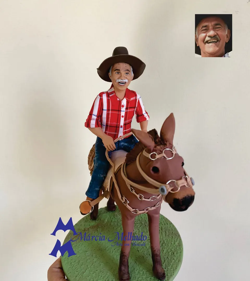 Boneco caipira de chapéu montado em mula com camisa xadrez Boneco de biscuit de senhor de bigode e chapéu com camisa xadrez vermelha montado em mula marrom com arreios, base verde