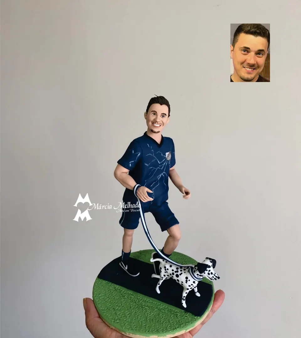 Boneco corredor com cachorro dálmata na coleira Boneco de biscuit de homem correndo com camiseta azul-marinho e bermuda, segurando a coleira de um cachorro dálmata