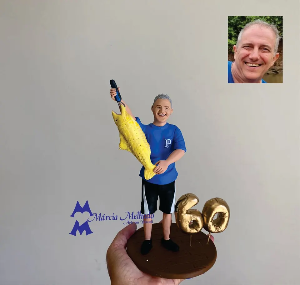 Boneco de aniversário 60 anos pescador com peixe dourado Boneco de biscuit de pescador sorridente com camisa azul do Palmeiras segurando um peixe dourado, ao lado do número 60
