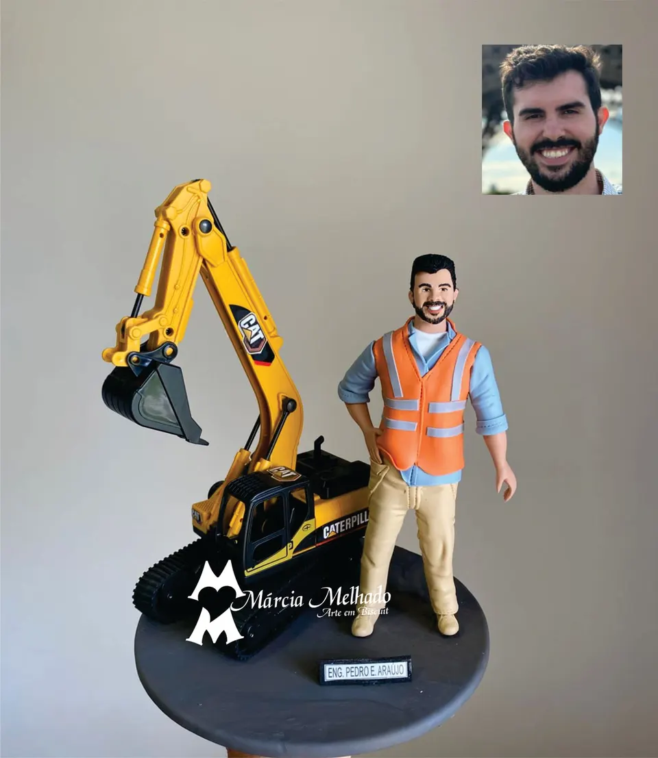 Boneco engenheiro com colete refletivo e escavadeira Caterpillar Boneco de biscuit de engenheiro de barba com colete laranja refletivo e camisa azul ao lado de escavadeira Caterpillar