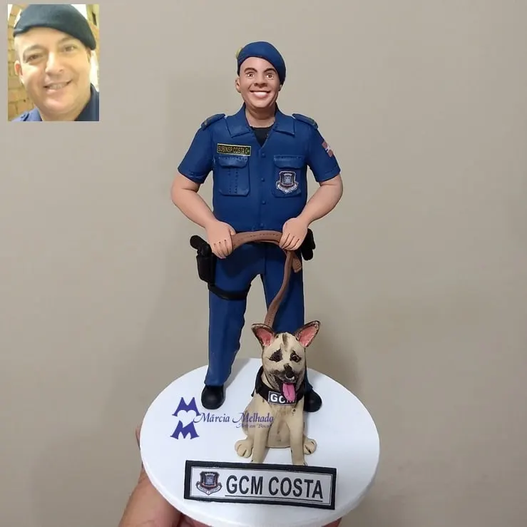 Boneco guarda civil municipal com cão pastor Boneco de biscuit de guarda civil municipal de farda azul e boina segurando a guia de um cão pastor com colete GCM