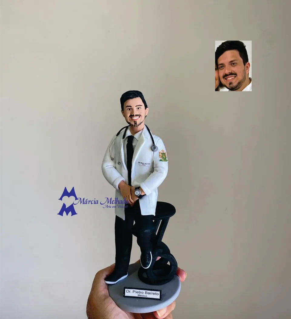 Boneco médico de jaleco e estetoscópio apoiado no banco Boneco de biscuit médico de jaleco branco, gravata preta e estetoscópio no pescoço apoiado em banco alto preto