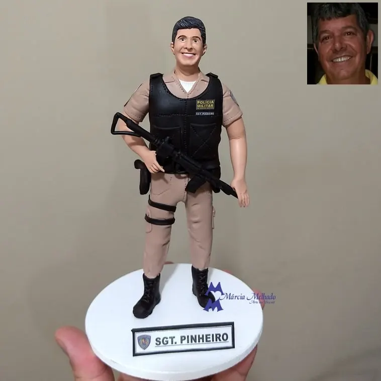 Boneco sargento da Polícia Militar com colete e fuzil Boneco de biscuit de sargento da Polícia Militar com farda bege, colete preto e fuzil nas mãos