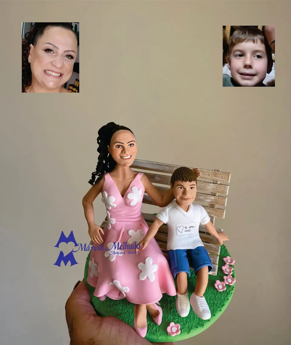 Bonecos de avó e neto em banco de jardim Bonecos de biscuit de avó com vestido rosa florido e neto de camiseta branca sentados em banco de madeira sobre grama