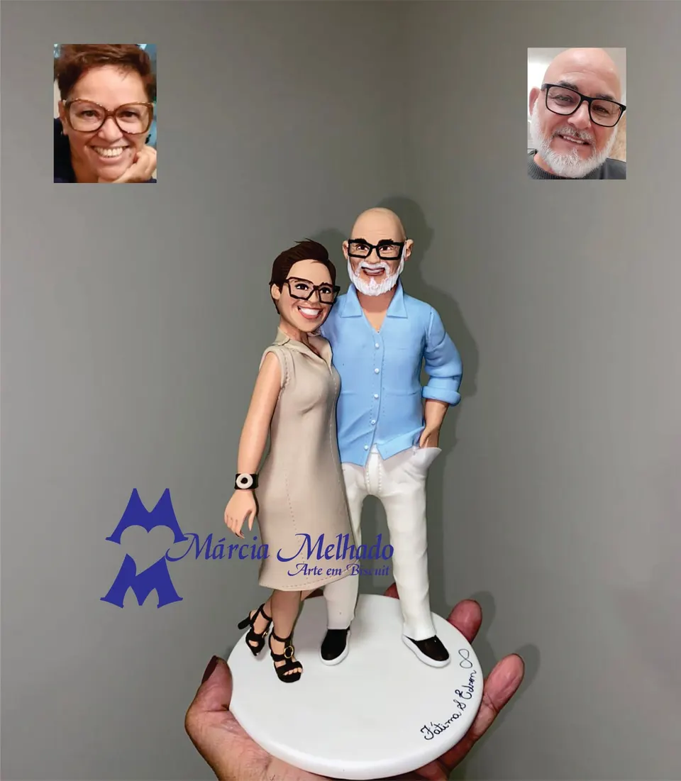 Bonecos de casal de óculos com vestido bege e camisa azul Bonecos de biscuit de casal abraçado, ela de vestido bege e óculos, ele careca de barba branca e camisa azul