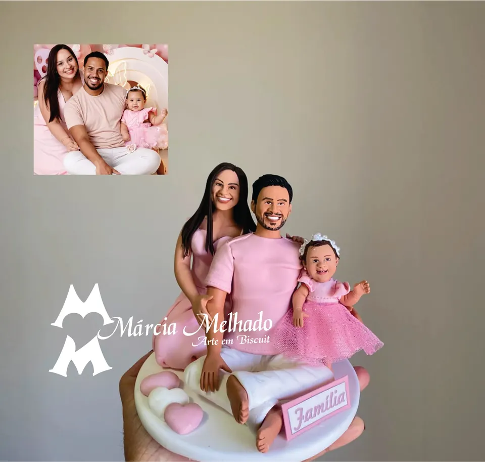 Bonecos de família com bebê em vestido rosa e plaquinha Bonecos de biscuit de família com mãe e pai de roupa rosa sentados e bebê de vestido de tule, plaquinha Família e corações