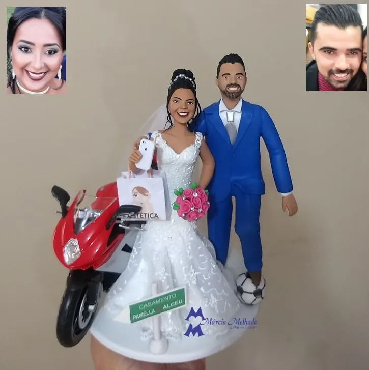 Noivinhos com moto esportiva, bola de futebol e sacola de estética Noivinhos de biscuit com noiva segurando celular e sacola, noivo de terno azul com bola de futebol e moto vermelha ao lado