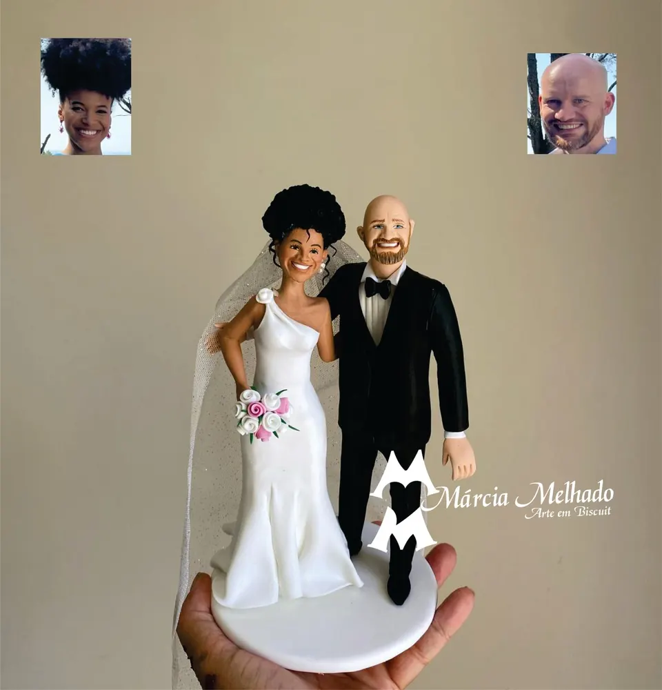 Noivinhos com noiva de vestido um ombro só e noivo de barba Noivinhos de biscuit: noiva de vestido branco de um ombro só com véu e buquê ao lado do noivo careca de barba e smoking preto