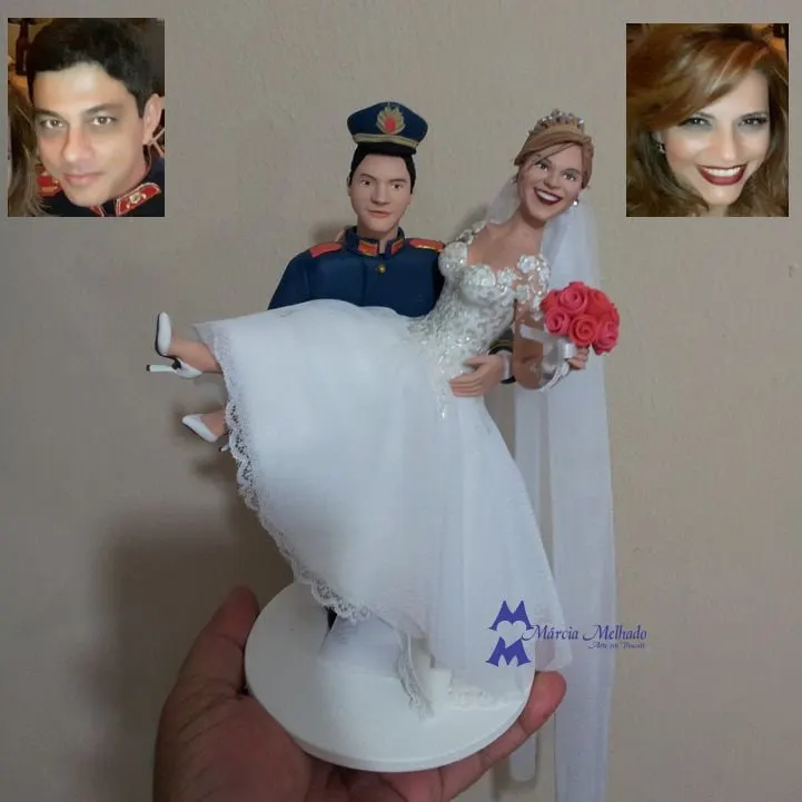 Noivinhos com noivo de farda de gala carregando a noiva no colo Noivinhos de biscuit: noivo de farda de gala azul carregando no colo a noiva de branco com buquê de rosas vermelhas