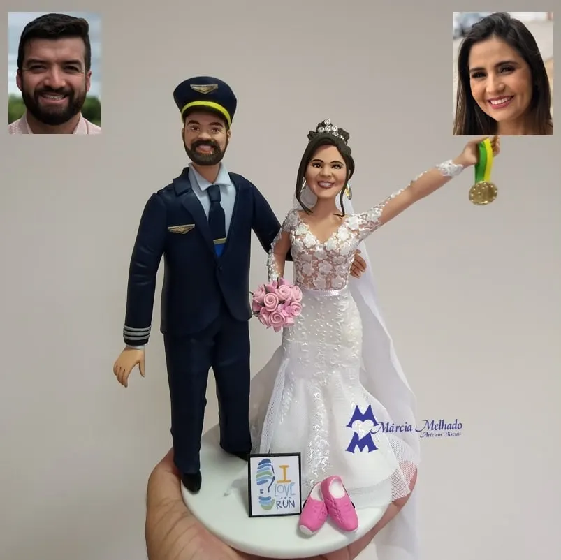 Noivinhos piloto de avião e noiva corredora com medalha Noivo de biscuit com farda de piloto de avião e quepe, noiva de vestido sereia erguendo medalha e tênis rosa na base