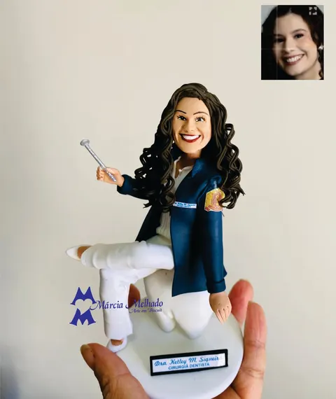 Boneca de biscuit de dentista com cabelo cacheado, blazer azul-marinho e calça branca segurando espelho bucal