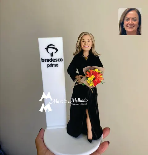 Boneca de biscuit de vestido preto longo com buquê de flores vermelhas e amarelas ao lado de totem do Bradesco Prime