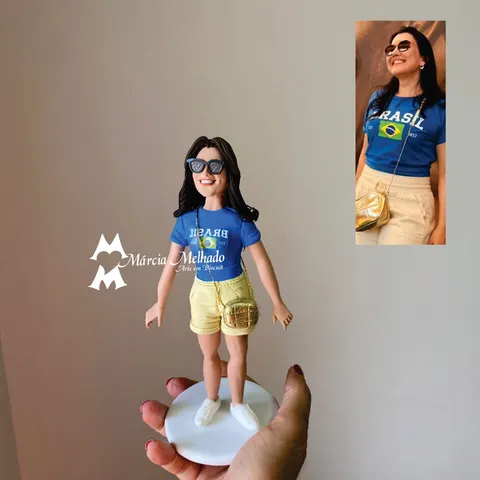 Boneca de biscuit de cabelo escuro com óculos de sol, camiseta azul do Brasil, shorts bege e bolsinha dourada a tiracolo