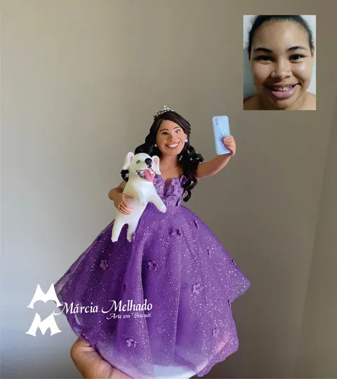 Boneca de biscuit de tiara e vestido lilás de tule com flores, segurando um cachorro branco e tirando selfie com o celular