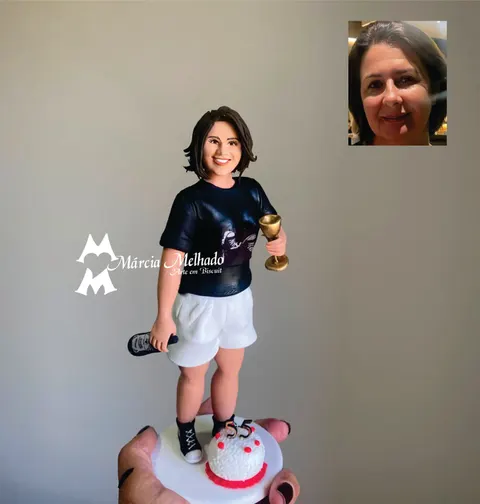 Boneca de biscuit com camiseta preta, shorts branco e tênis All Star segurando taça e garrafa, com bolo e vela 55