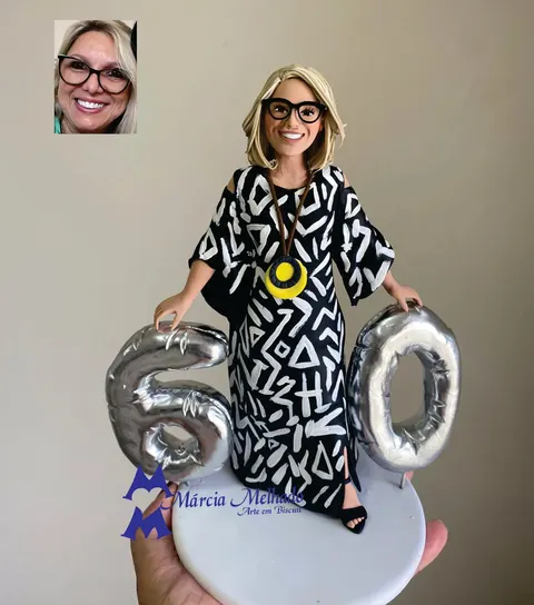 Boneca de biscuit de mulher loira de óculos com vestido preto estampado entre balões prateados do número 60