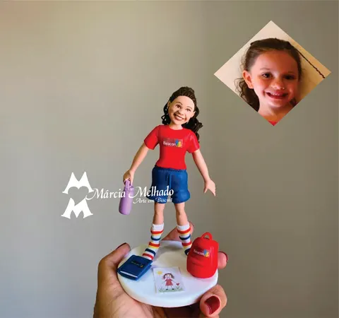 Boneca de biscuit de menina com uniforme escolar vermelho e azul, meias listradas, mochila vermelha e caderno na base