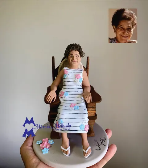 Boneca de biscuit de senhora de cabelo cacheado sentada em cadeira de madeira, vestido listrado com flores e chinelos brancos