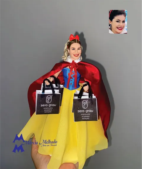 Boneca de biscuit vestida de Branca de Neve, com laço vermelho, capa de cetim e saia amarela, segurando duas sacolas pretas