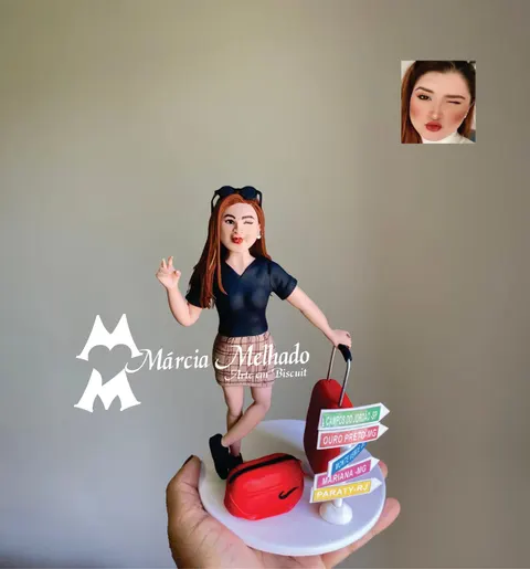 Boneca de biscuit de mulher ruiva piscando, com mala vermelha, pochete vermelha e placas com nomes de cidades turísticas