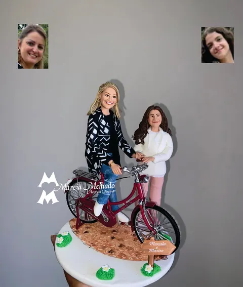 Duas bonecas de biscuit com bicicleta vermelha, uma loira de casaco estampado no selim e uma jovem morena ao lado