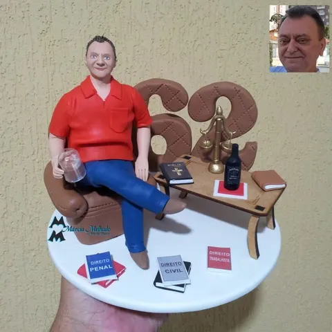 Boneco de biscuit de senhor de camisa vermelha em poltrona com copo, balança da justiça, livros de direito e número 62