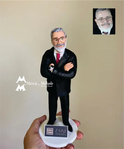 Boneco de biscuit de advogado grisalho de óculos e barba branca com terno preto e gravata vermelha, braços cruzados