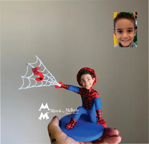 Boneco de biscuit de menino com fantasia do Homem-Aranha agachado, lançando uma teia branca com o número 5 em vermelho