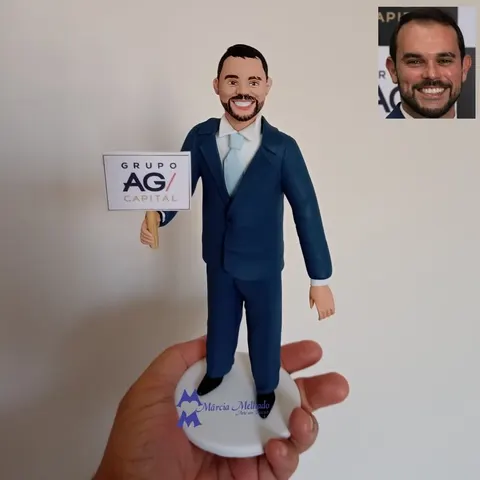 Boneco de barba e terno azul-marinho com gravata clara segurando placa com logotipo de empresa sobre base branca