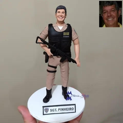 Boneco de biscuit de sargento da Polícia Militar com farda bege, colete preto e fuzil nas mãos
