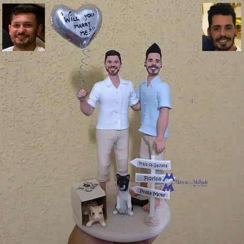 Bonecos de biscuit de dois homens abraçados com balão de coração prateado, dois gatos e placas de praias de Floripa.