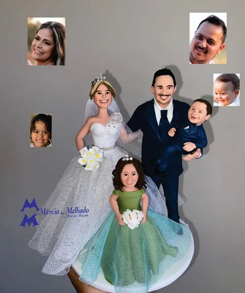 Noivinhos de biscuit com noiva de véu e buquê, noivo de terno azul com bebê no colo e menina de vestido verde com alianças