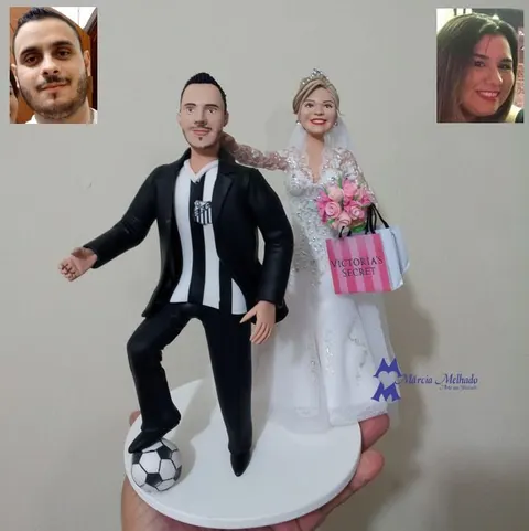 Noivinhos de biscuit: noivo com camisa do Santos e pé na bola, noiva de vestido rendado com buquê rosa e sacola de compras